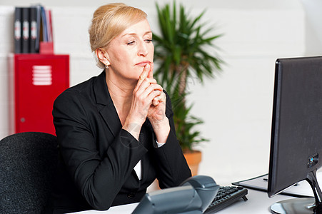 调查计算机屏幕的公司女公司主女士键盘女性冒充人士桌子经理老板中年思想家思维图片