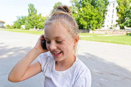 可爱的女孩通过手机聊天细胞孩子金发电话童年白色女学生女性女士背景图片