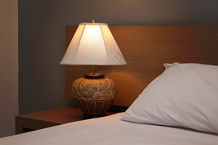 带床铺的台灯桌子床罩卧室白色枕头酒店家具床头板灯光公寓图片