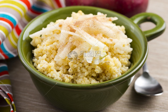 加苹果和肉桂的甜小米粥片黄色粮食谷物稀饭早餐勺子玻璃煮沸服务南瓜图片