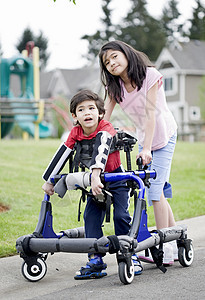 姐姐帮助行尸中残疾弟弟的年青妹妹轮子矫形需求保姆乐趣机动性健康混血孩子减值图片