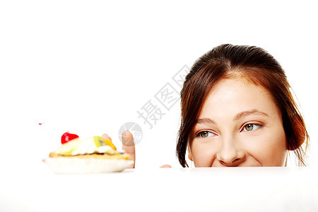 女孩躲在桌子后面 伸手拿蛋糕图片