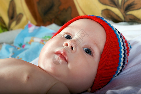 美丽婴儿的近视肖像嘴唇情感乐趣说谎生活新生蓝色帽子皮肤喜悦图片