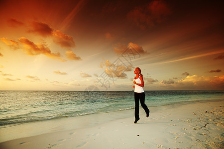 妇女逃亡女士阳光慢跑者练习天空日落火车海洋慢跑海滩图片