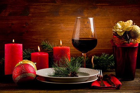 喝红酒装饰的圣诞节表木头派对高脚杯空气装饰品节日金子红色松树蜡烛背景