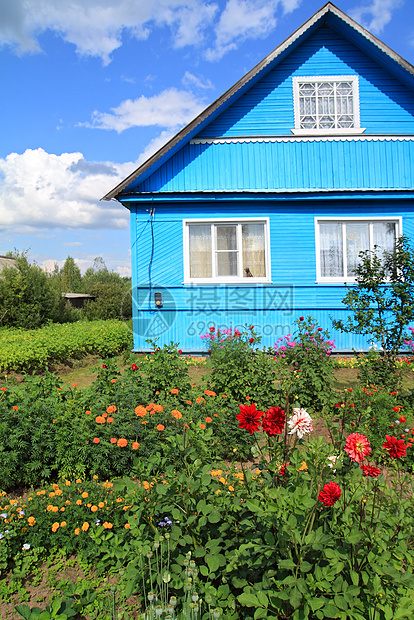 农村木制建筑附近的鲜花图片