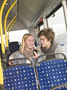 公车上的一对夫妇座椅手机内饰车辆椅子运输陆地恋人驾驶窗户图片
