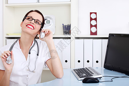 女医生通过电话说话办公室专家女性水平微笑医疗职场桌子眼镜保健图片