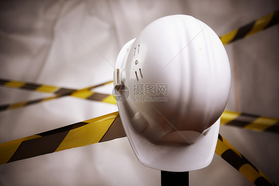 正在施工中白色安全帽黑色建造危险磁带职业条纹水平头盔图片