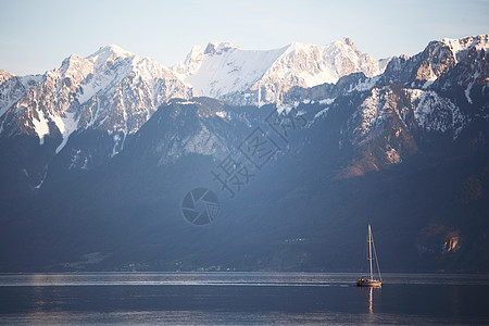 湖湖基因海岸线场景涟漪山脉村庄反射崎岖天空远景帆船图片