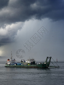 渡轮天空戏剧性渡船货物血管雷雨风险危险船运地平线图片