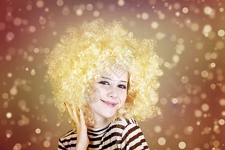 穿着金发假发的可笑女孩的肖像化妆品撒娇条纹成人女性喜剧明星工作室派对情感图片
