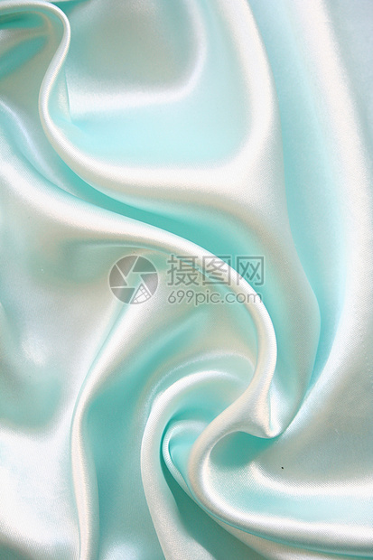 平滑优雅的蓝色丝绸作为背景银色材料白色折痕投标织物纺织品曲线布料图片