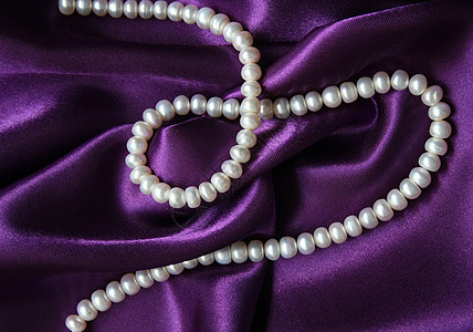 白珍珠 以丝绸上的白珍珠为背景女性化白色魅力细绳宝藏紫丁香光泽度珠子手镯项链图片