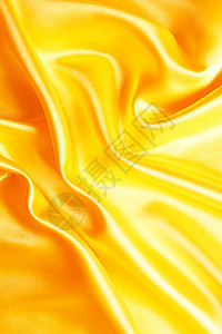 平滑优雅的金色丝绸作为背景曲线布料材料织物金子涟漪黄色折痕投标纺织品图片