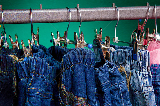 商店儿童衣架上的Denim裤子棉布纺织品活力衣服织物店铺零售牛仔裤架子服装图片