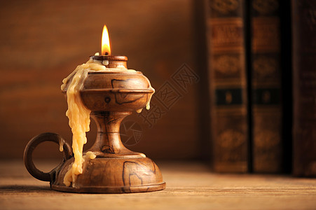 木桌上的旧蜡烛 背景中的旧书棕色桌子小路历史木头绿色打印黑色古董艺术图片