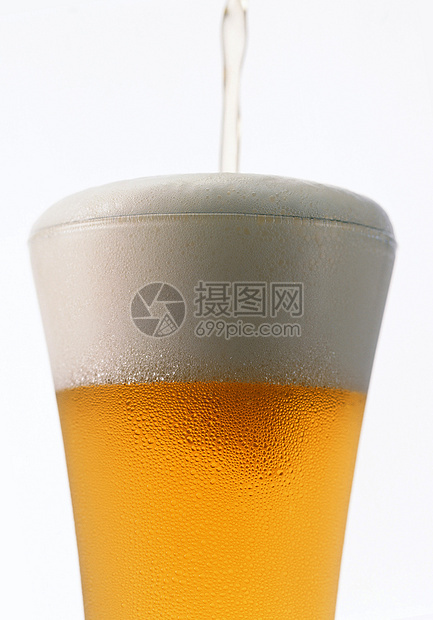 轻啤酒倒在玻璃杯中 隔着白色图片
