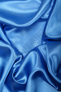 平滑优雅的蓝色丝绸作为背景天蓝色折痕投标海浪曲线纺织品银色织物布料材料图片