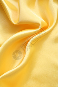 平滑优雅的金色丝绸可用作背景纺织品材料涟漪织物折痕投标黄色海浪布料曲线图片