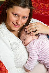 母亲拥抱婴儿入睡父母孩子甜蜜尿布家庭微笑粉色图片