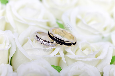 白色玫瑰花束上的两个结婚戒指图片