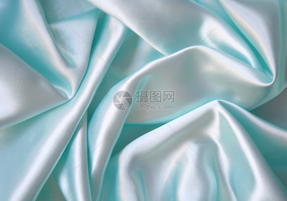 平滑优雅的蓝色丝绸作为背景布料曲线织物投标折痕海浪银色材料纺织品图片