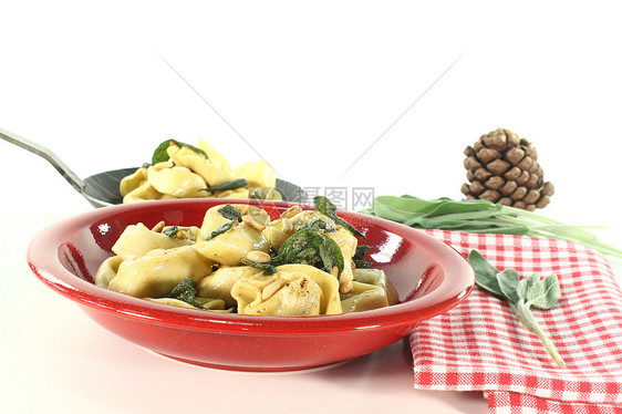 带圣子的托尔特利尼食物智者饺子乳制品盘子黄油素食美食松子图片