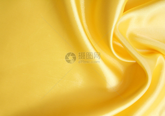 平滑优雅的金色丝绸可用作背景黄色投标曲线材料纺织品折痕布料涟漪织物图片