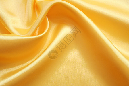 平滑优雅的金色丝绸可用作背景海浪投标布料织物折痕黄色材料纺织品涟漪曲线图片