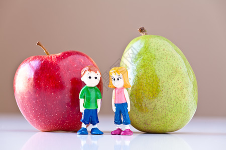 讨论健康营养的女童和男孩梨和苹果棕色水果深红色红色白色女孩合伙玩具绿色男生图片