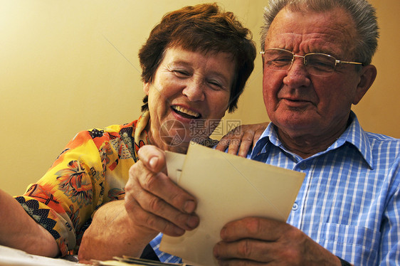年长夫妇看旧相片夫妻怀旧祖父祖母闲暇记忆阅读眼镜生活图片