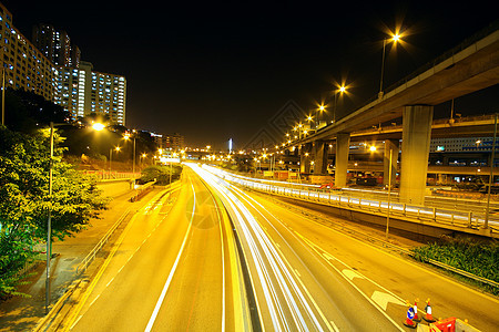 在现代城市的夜间高速公路建筑运动收费运输条纹交通时间日落速度商业图片