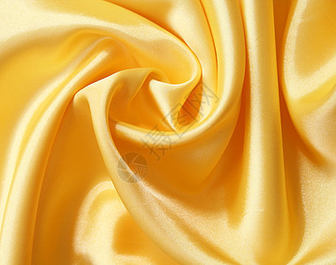 平滑优雅的金色丝绸可用作背景涟漪布料海浪纺织品黄色材料折痕曲线投标织物图片