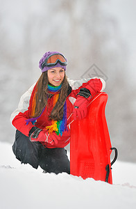 年轻美丽的女子在冬季玩耍说谎季节雪橇黑发微笑快乐假期女孩女士情感图片