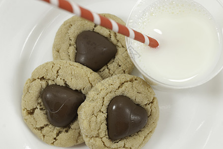 三个巧克力心和牛奶的饼干 上面有巧克力心图片