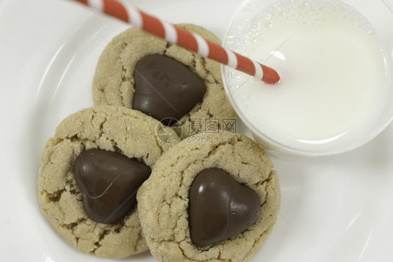 三个巧克力心和牛奶的饼干 上面有巧克力心图片