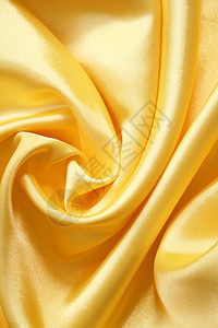 平滑优雅的金色丝绸可用作背景材料曲线投标纺织品黄色布料海浪涟漪织物折痕图片