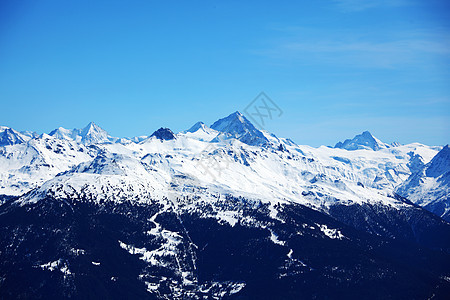 山上有高山季节暴风雪滑雪板顶峰天空高度太阳阴霾蓝色全景图片