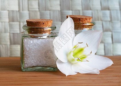 装有白花的海水盐和油瓶石头草本植物洗澡芳香生活植物手工香水奢华化妆品图片