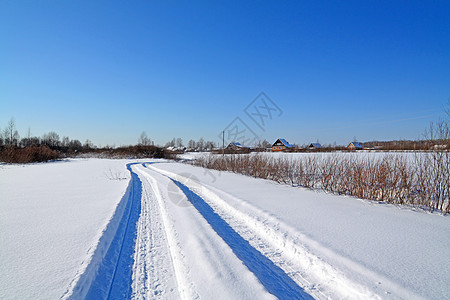 靠近村庄冬季的雪路图片