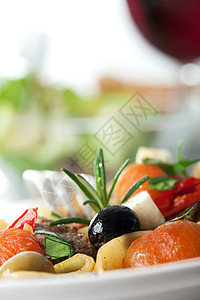 以西红柿和橄榄末面糊香料立方体牛肉沙拉面条食物丝带玻璃香菜迷迭香图片