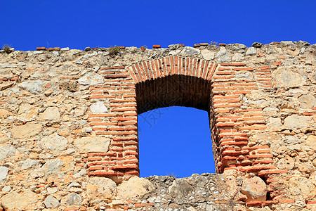 古石岩石墙中的砖块形拱门图片