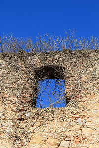 古古城堡墙窗被攀爬植物侵入裂缝古董水泥废墟砂浆石工房子石头天空材料图片
