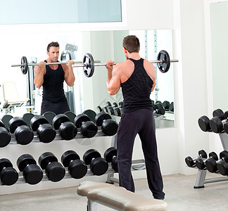具有哑铃机重量训练设备体操的男子镜子火车身体运动员健美运动反射健身房培训师肌肉图片