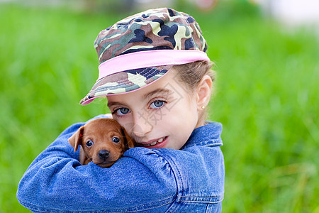 带着宠物小狗吉祥物的小姑娘尺寸孩子别针犬类女孩微笑毛皮幸福女性蓝色图片