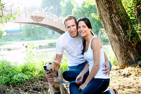 在户外河里爱狗的情侣动物宠物婴儿猎犬友谊吉祥物朋友公园女孩男性图片