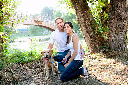 在户外河里爱狗的情侣公园女性女士家庭朋友动物友谊微笑小狗宠物图片