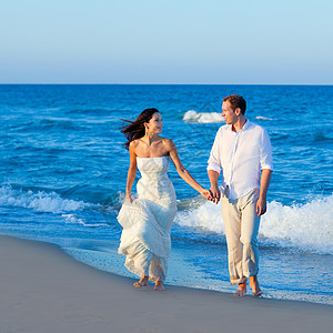 地中海夫妇在蓝色海滩上行走波浪裙子幸福海洋男性夫妻庆典情感假期女士图片