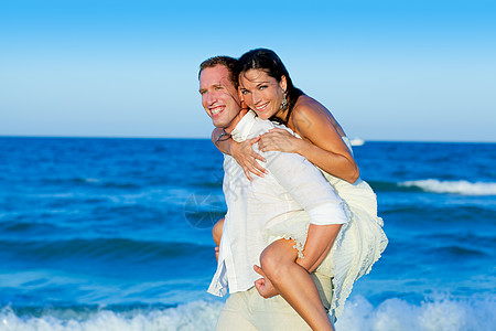 情侣在海滩玩情马背游戏女性女孩成人波浪海洋裙子微笑男人婚姻蜜月图片